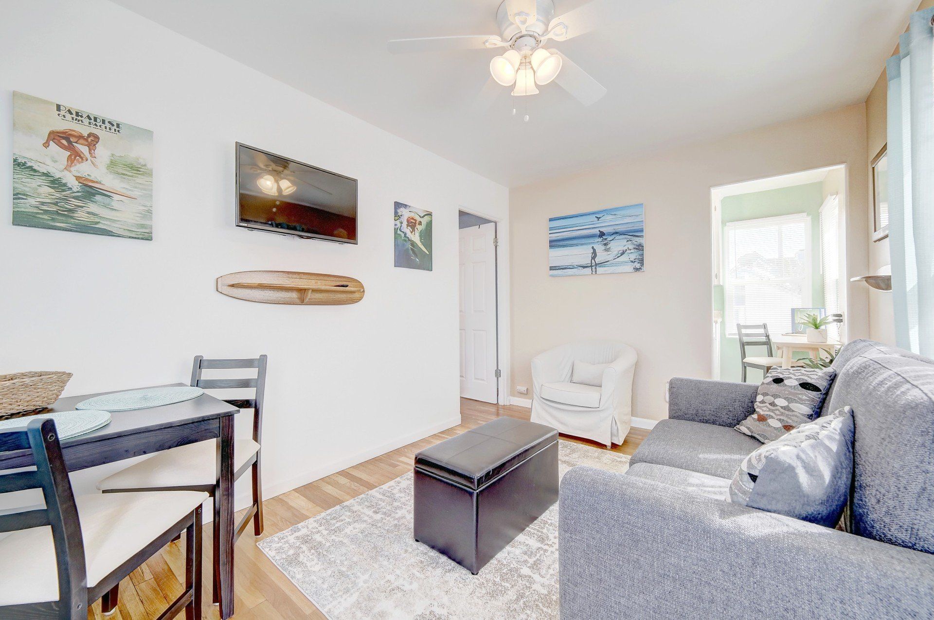 A living room with a couch , table , chairs and a television.