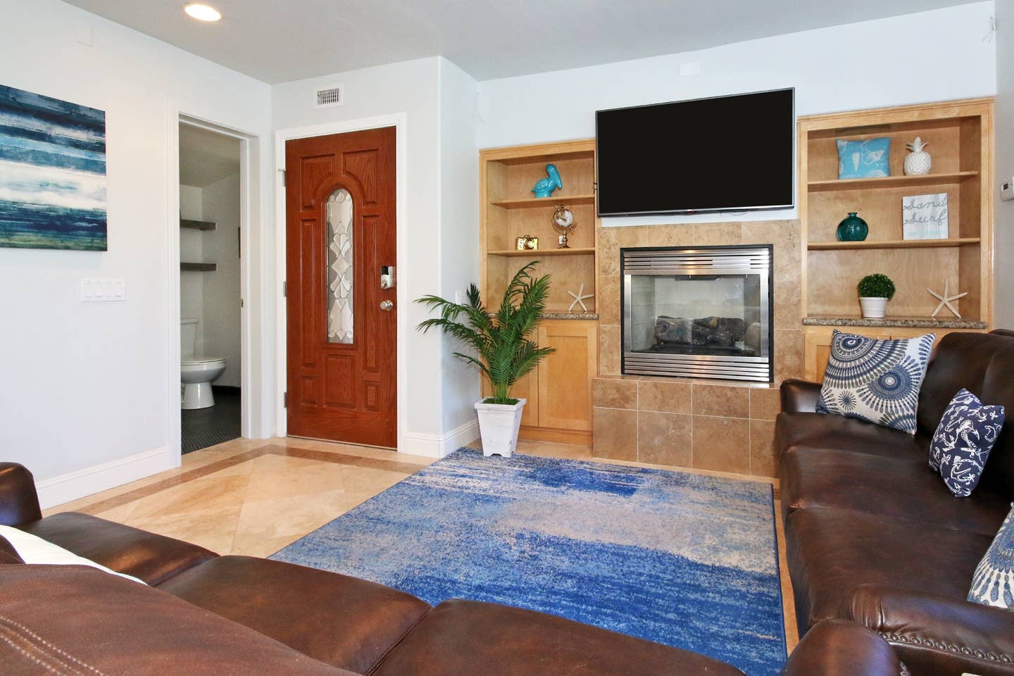 A living room with a couch , fireplace and television.