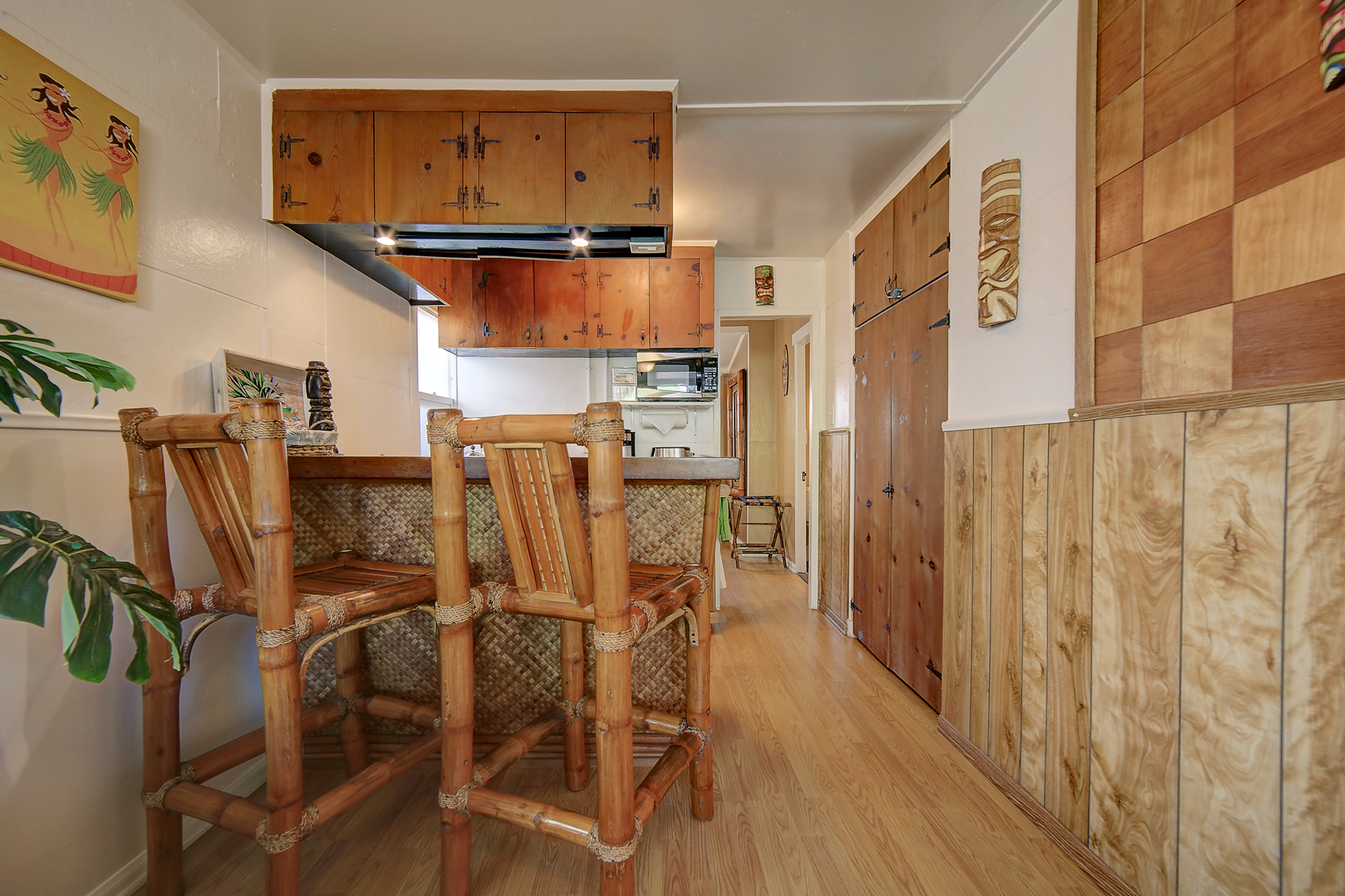 A kitchen with a bar and chairs made of bamboo