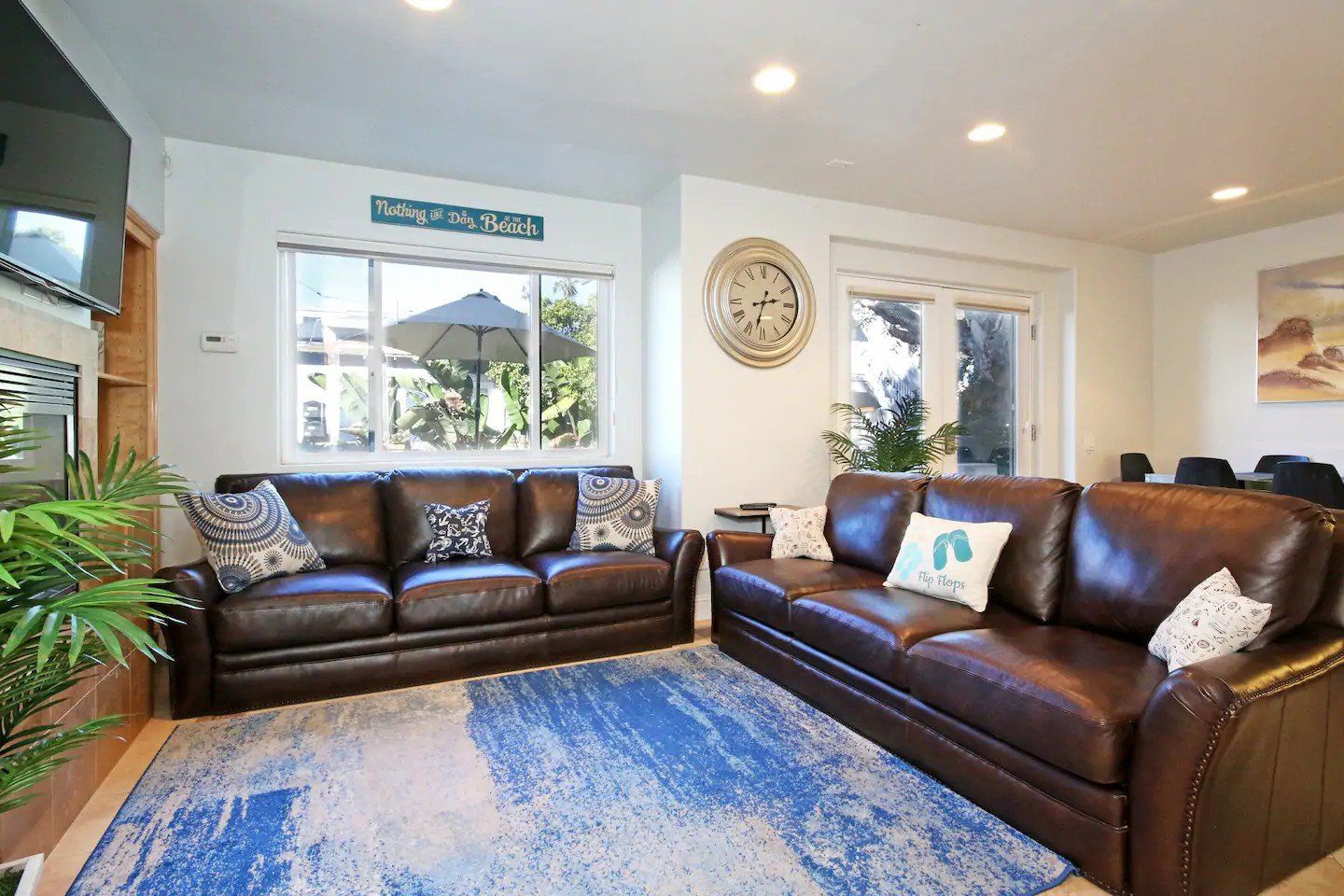 A living room with two couches and a blue rug.