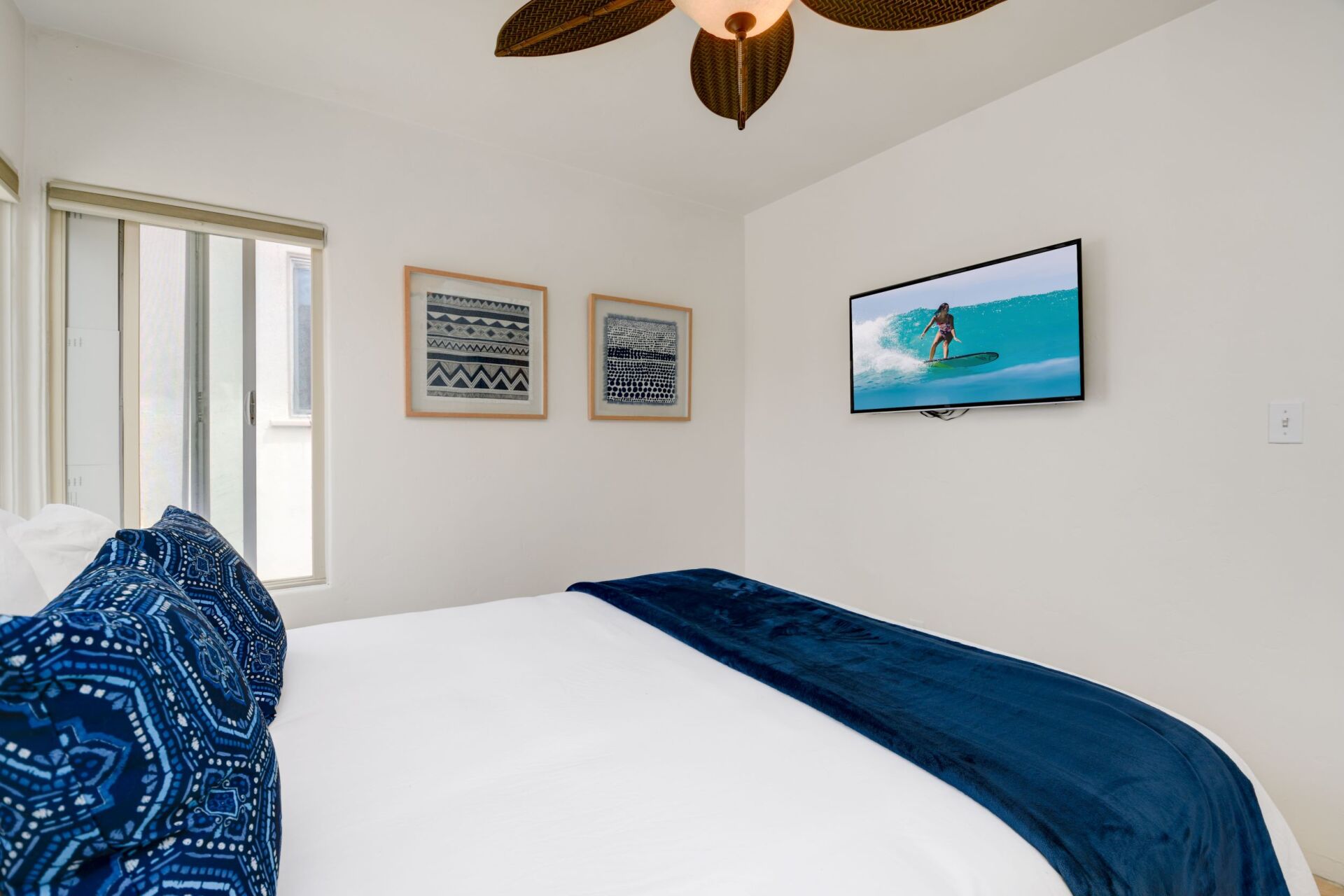 a bedroom with a bed , television and ceiling fan .