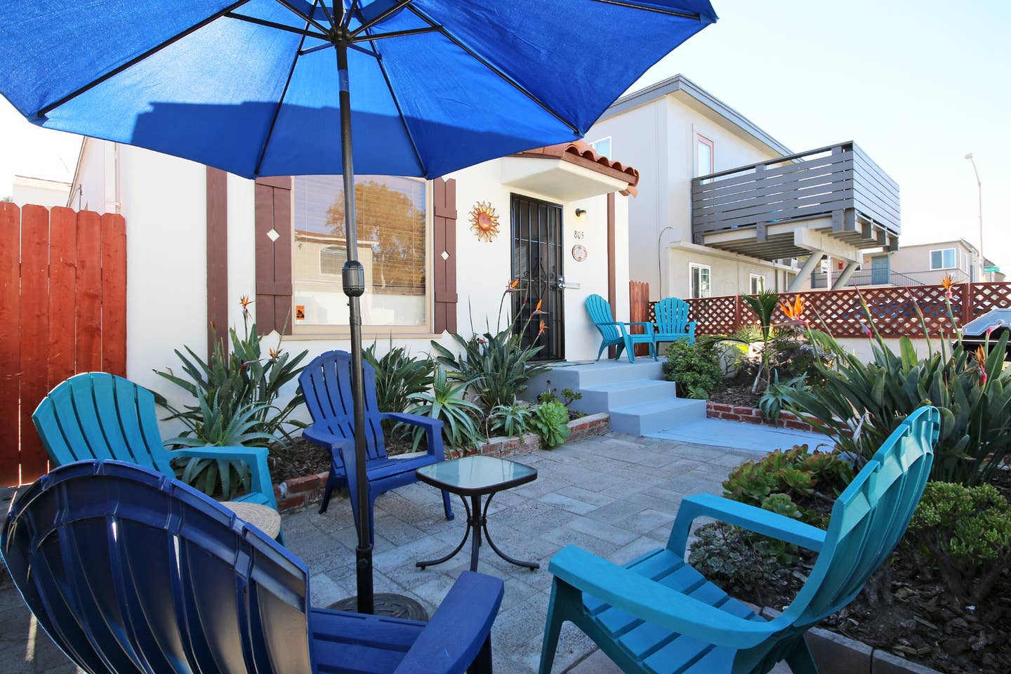 a patio with blue chairs and a blue umbrella