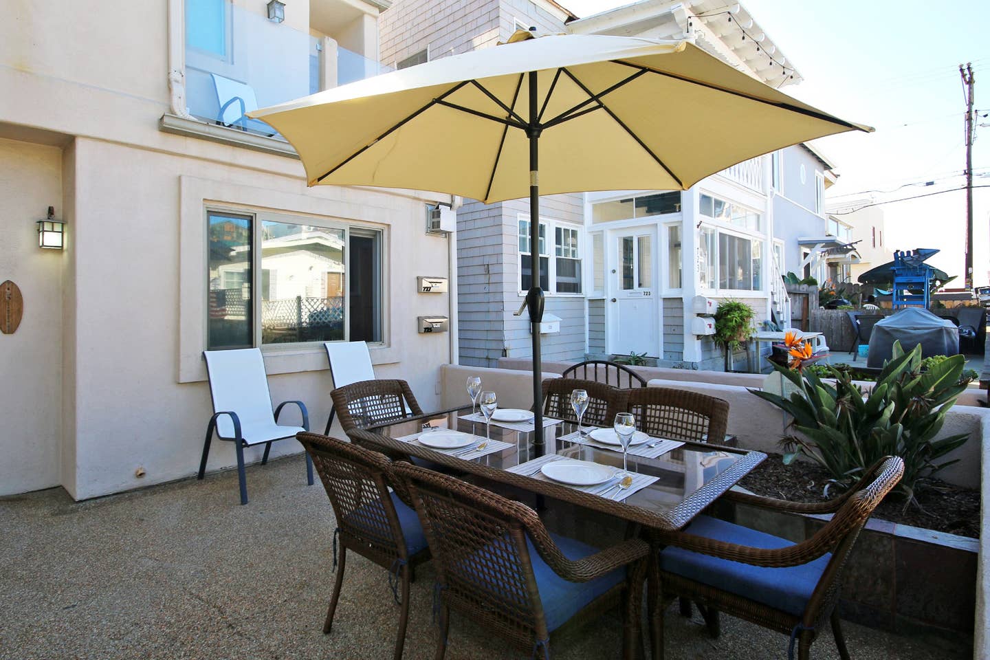 a patio with a table and chairs under an umbrella