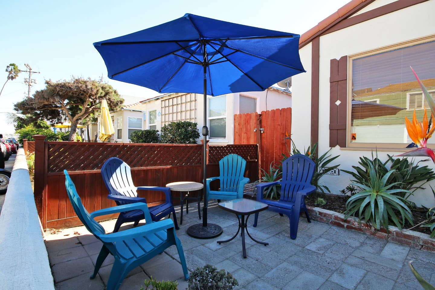 a patio with blue chairs and a blue umbrella