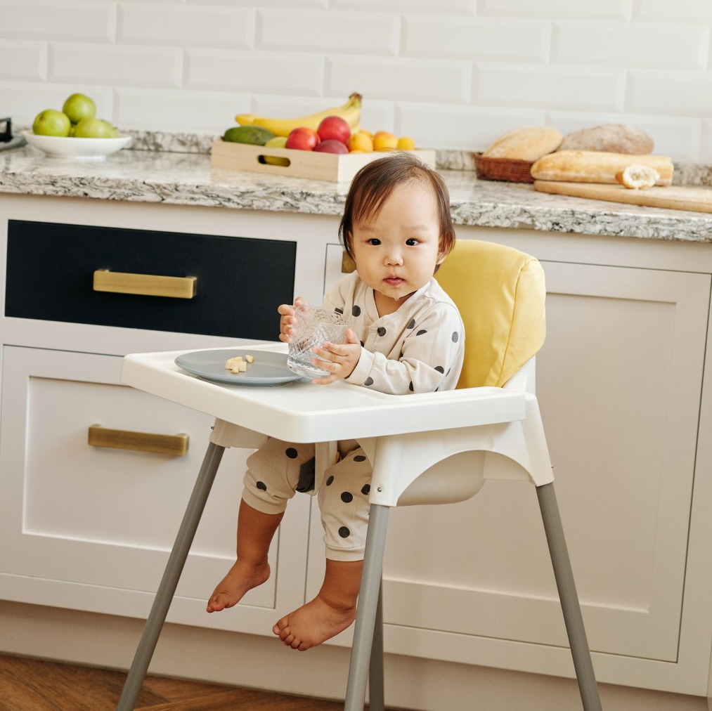 a baby is sitting in a high chair in a kitchen