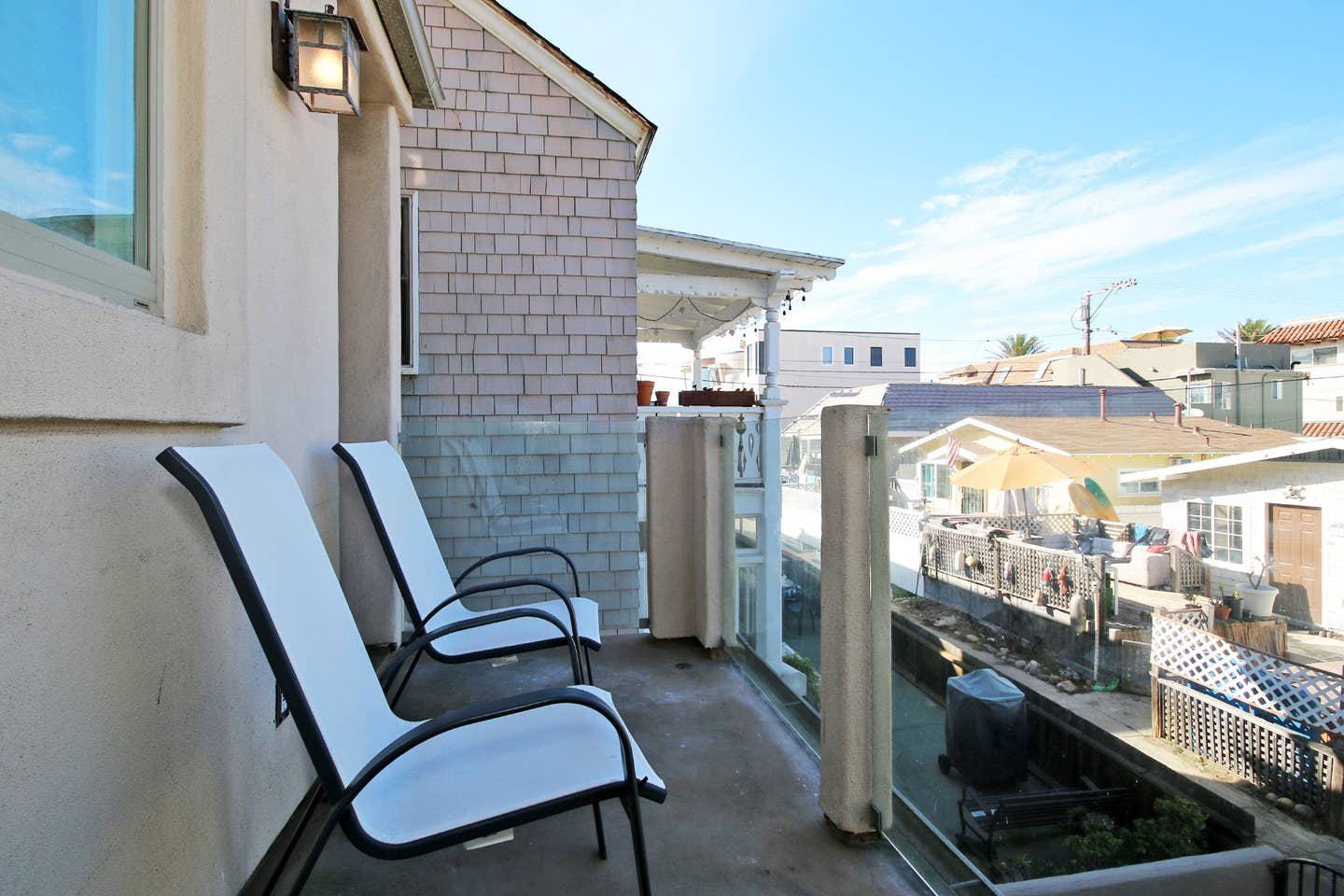 A balcony with two chairs and a glass railing