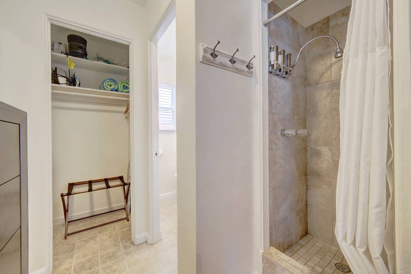 A bathroom with a walk in shower and a closet.