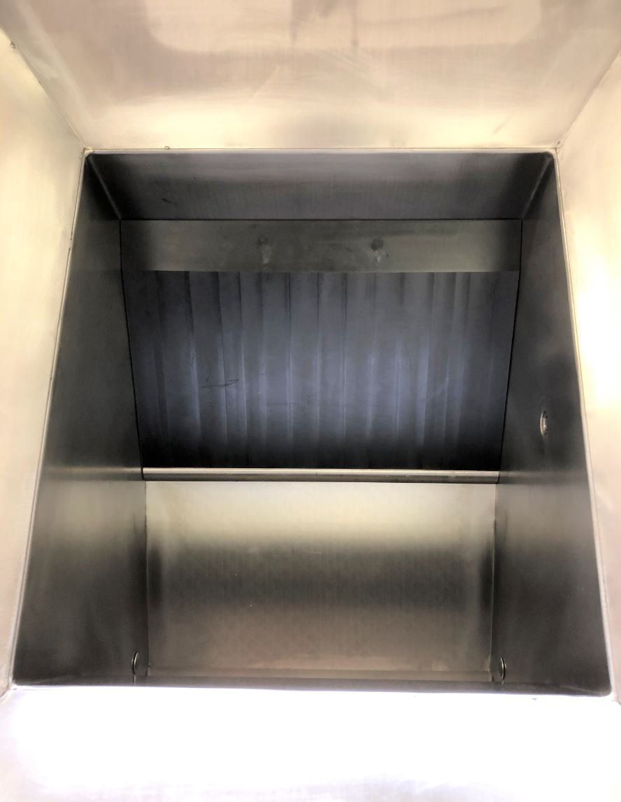 Das Innere eines Edelstahlbehälters mit Ablagefläche.