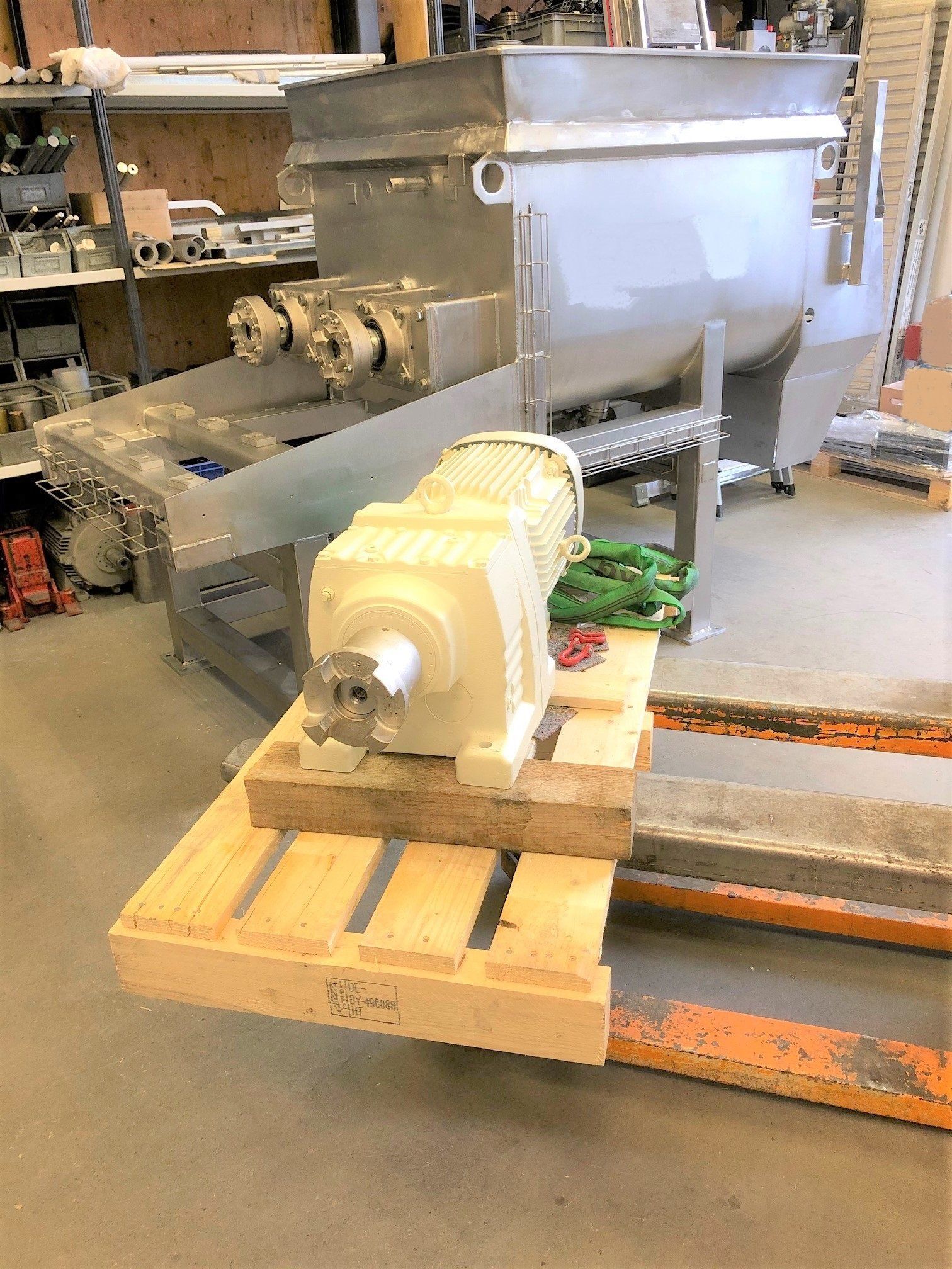 In einer Fabrik steht eine Maschine auf einer Holzpalette.