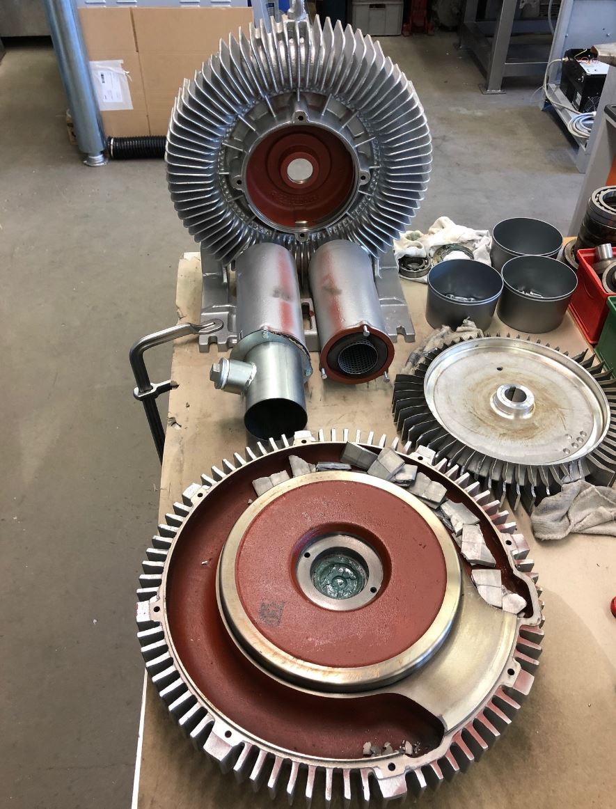 Auf einem Tisch wird eine Maschine zerlegt.