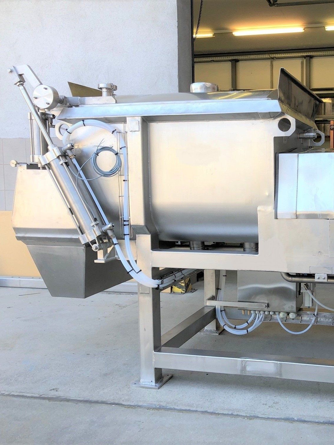 Eine große Maschine aus Edelstahl steht in einer Garage