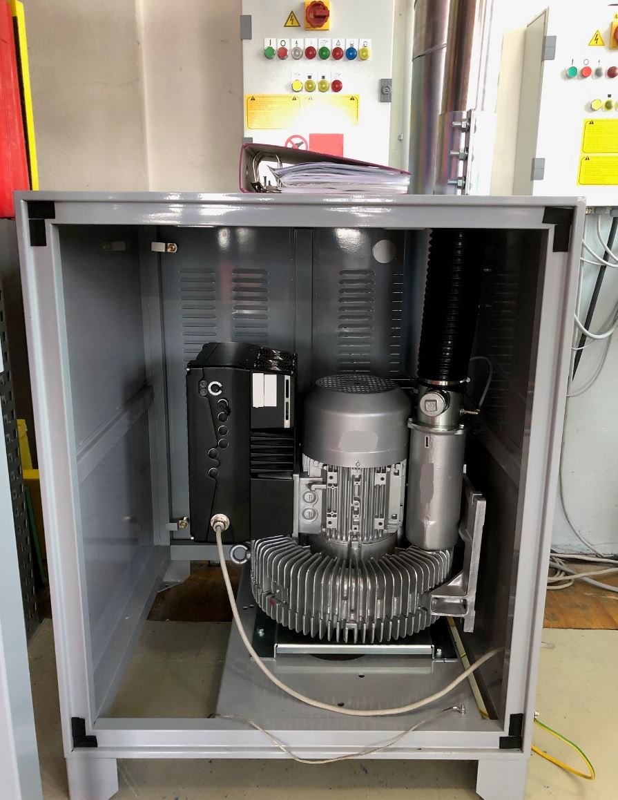 Eine Maschine steht in einem Metallschrank.