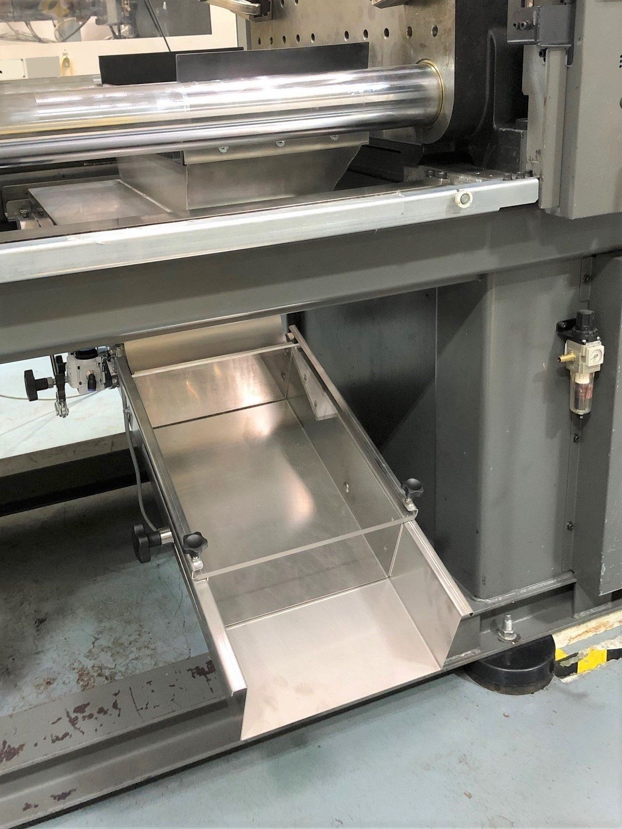 Eine Maschine mit einer Edelstahlschublade darunter.