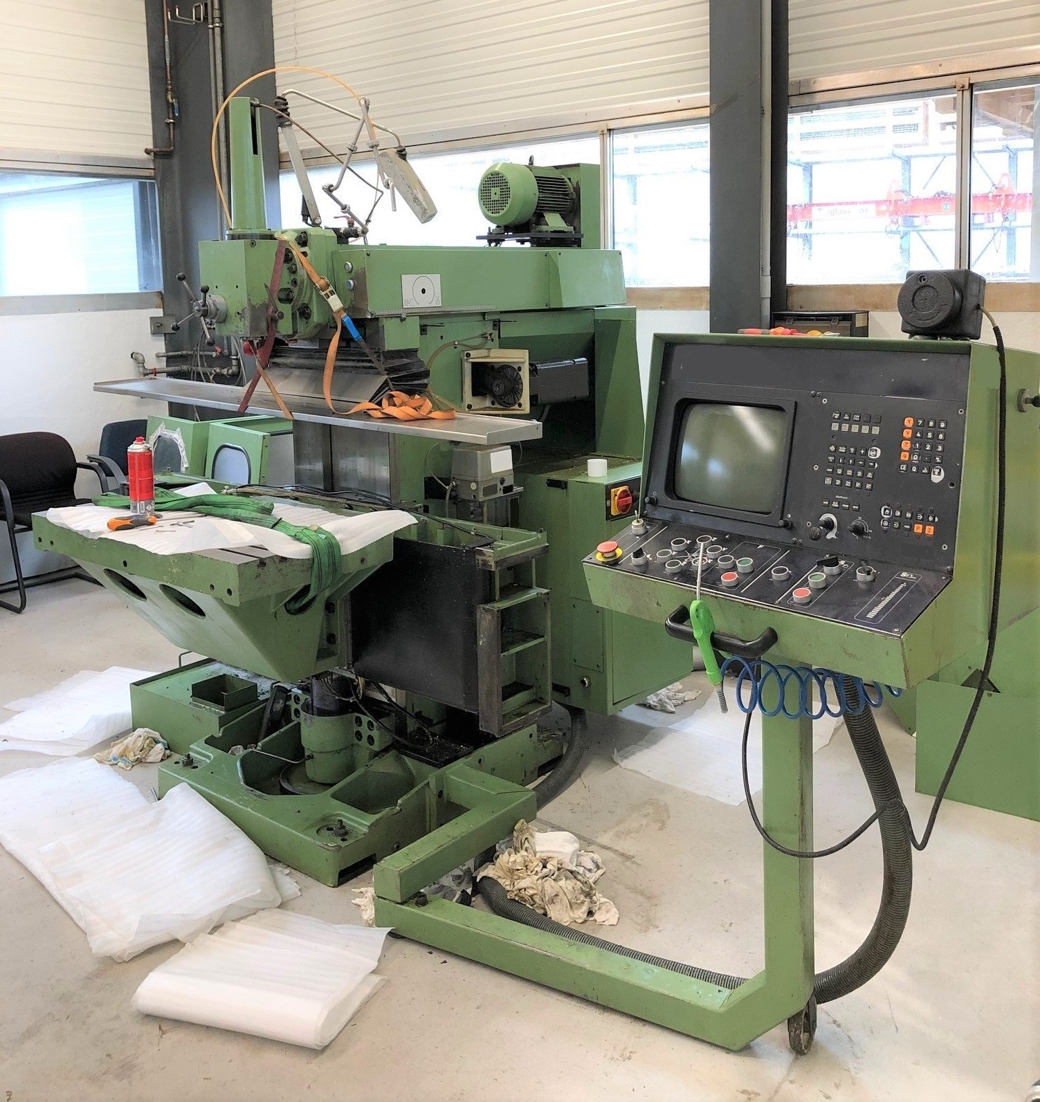 Eine grüne Maschine steht in einem Raum neben einem Bedienfeld