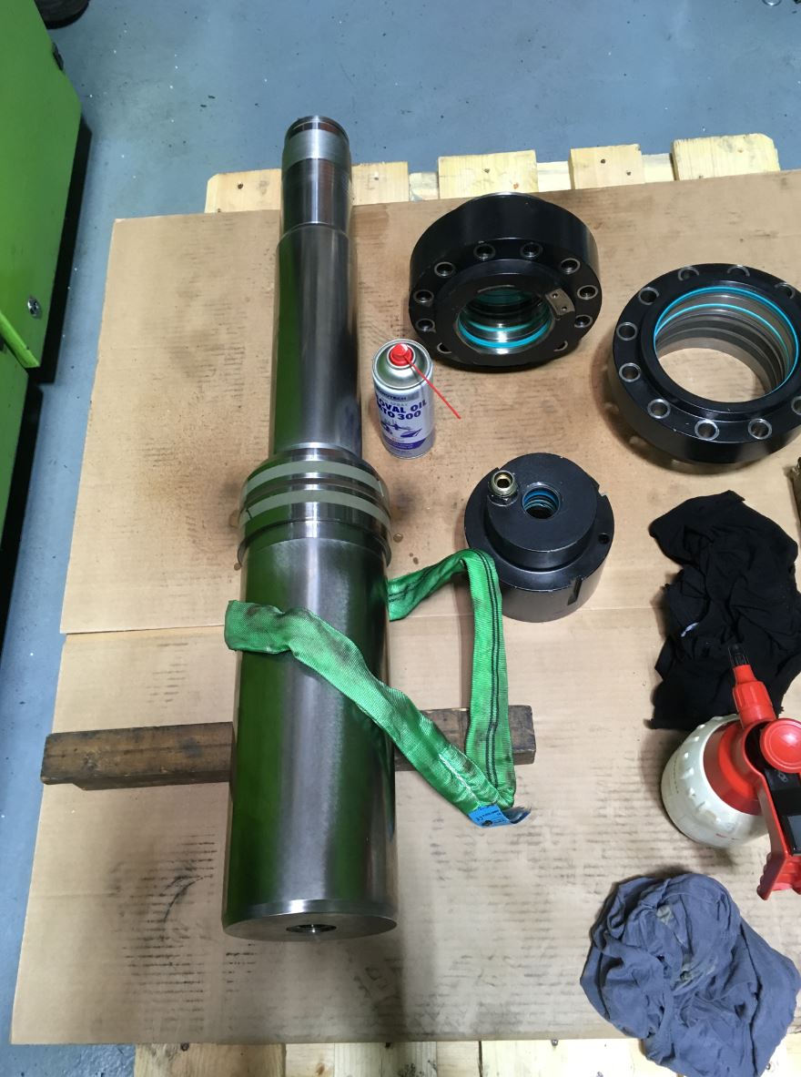 Auf einem Holztisch liegt ein großes Metallobjekt.