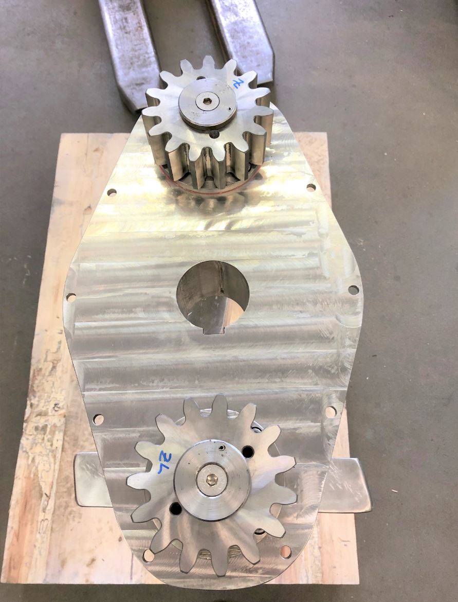 Auf einem Holztisch liegt ein Metallzahnrad.