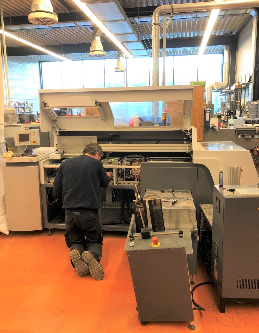 Ein Mann arbeitet in einer Fabrik an einer Maschine.