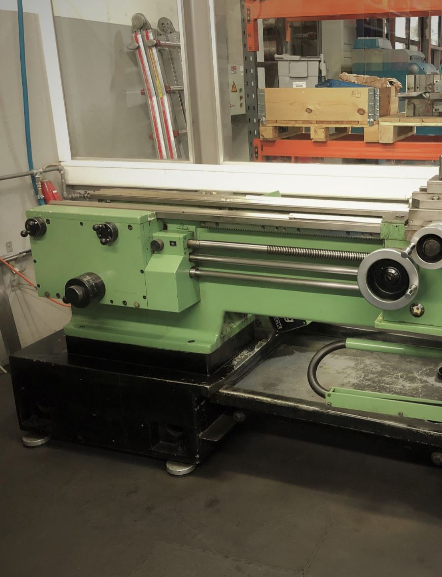 In einem Fabrikraum steht eine grüne Drehbank.