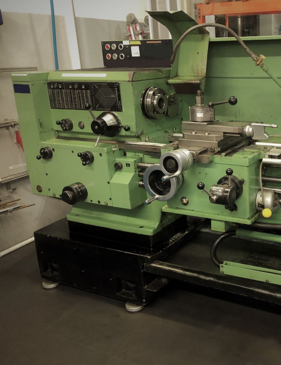 Eine grüne Drehbank steht auf dem Boden in einem Zimmer