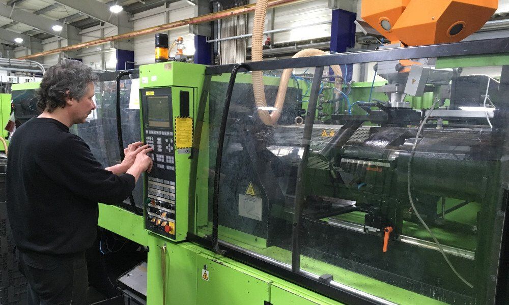 Ein Mann arbeitet in einer Fabrik an einer Maschine.