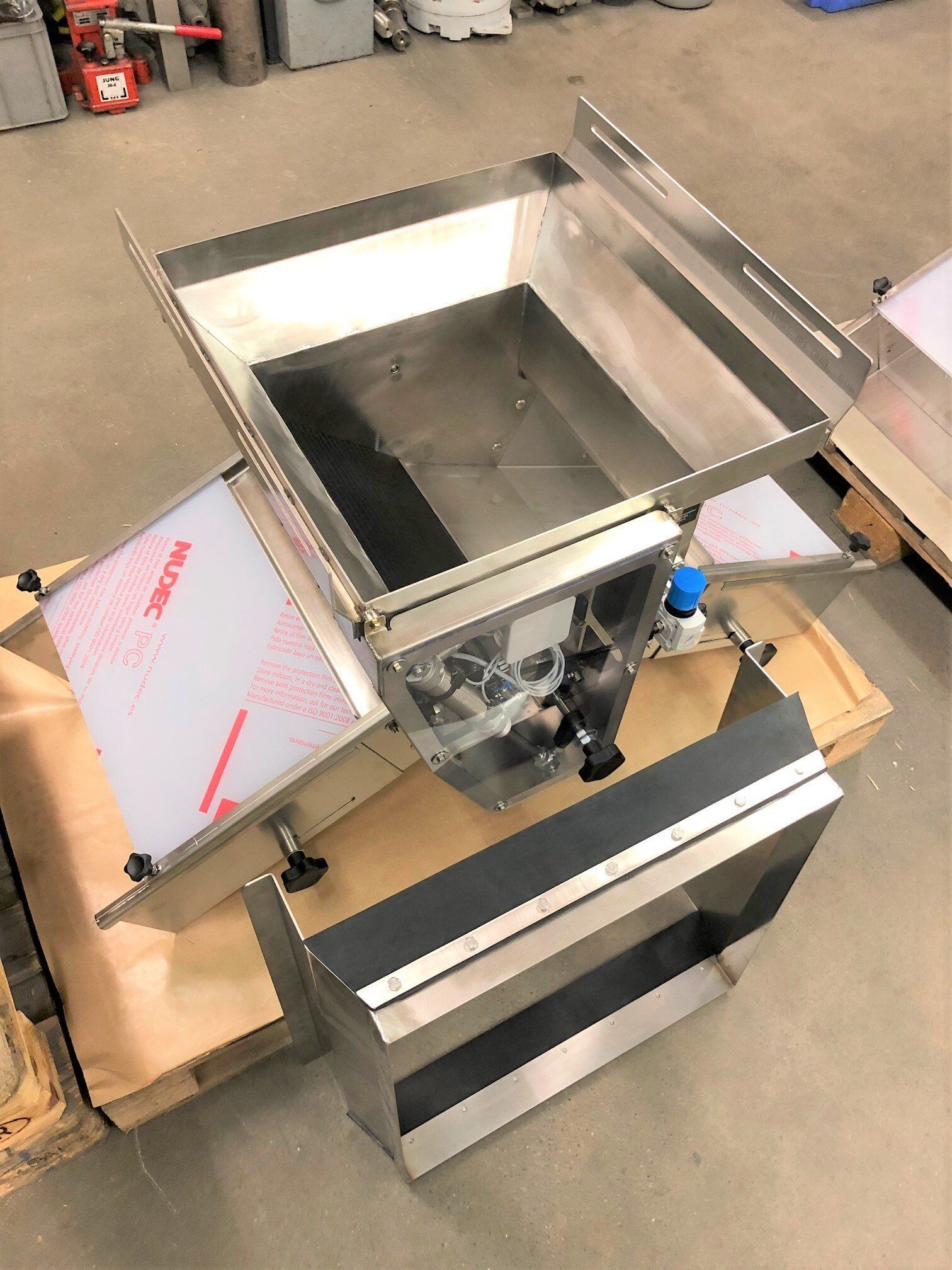 Auf einem Holztisch steht eine Maschine aus Edelstahl.