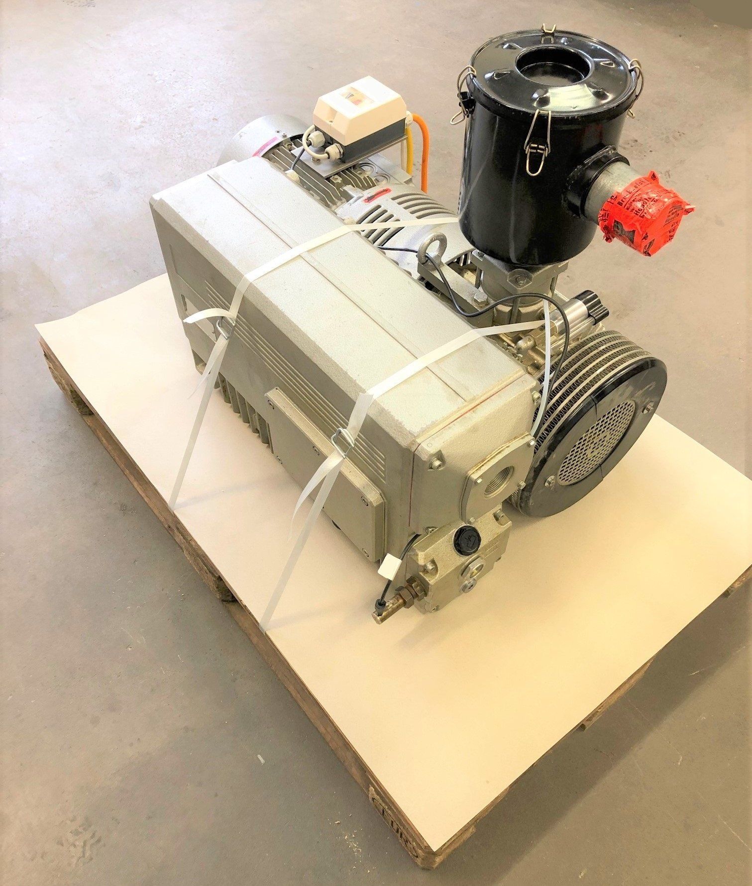 Auf einer Holzpalette steht ein Staubsauger.