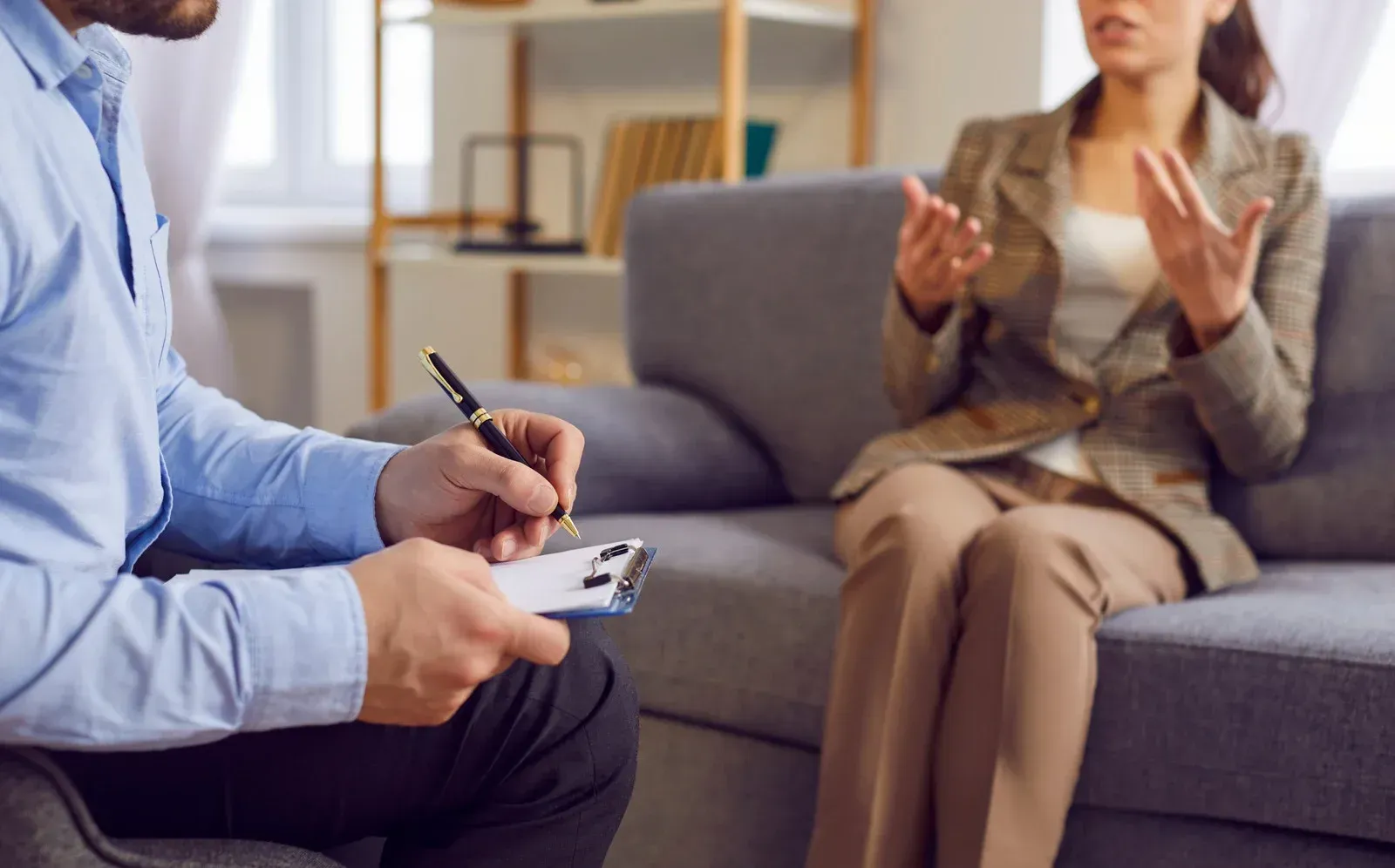 A man is sitting on a couch talking to a woman.
