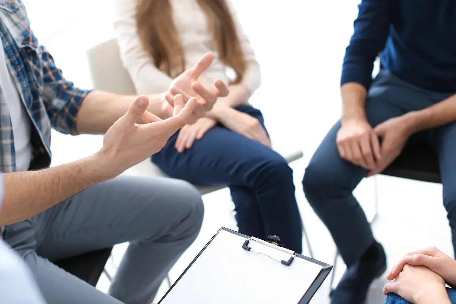 A group of people are sitting in a circle talking to each other.