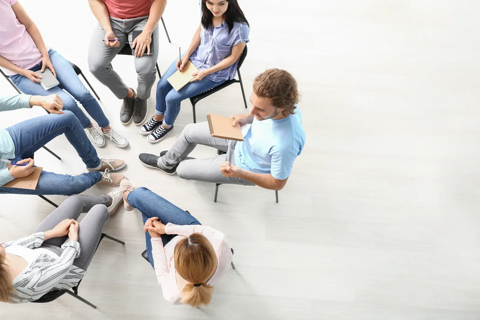 A group of people are sitting in a circle on the floor.