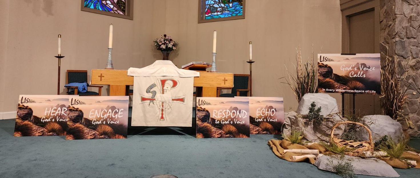 People holding up colorful papers, looking upward in a sunny outdoor setting near a building.
