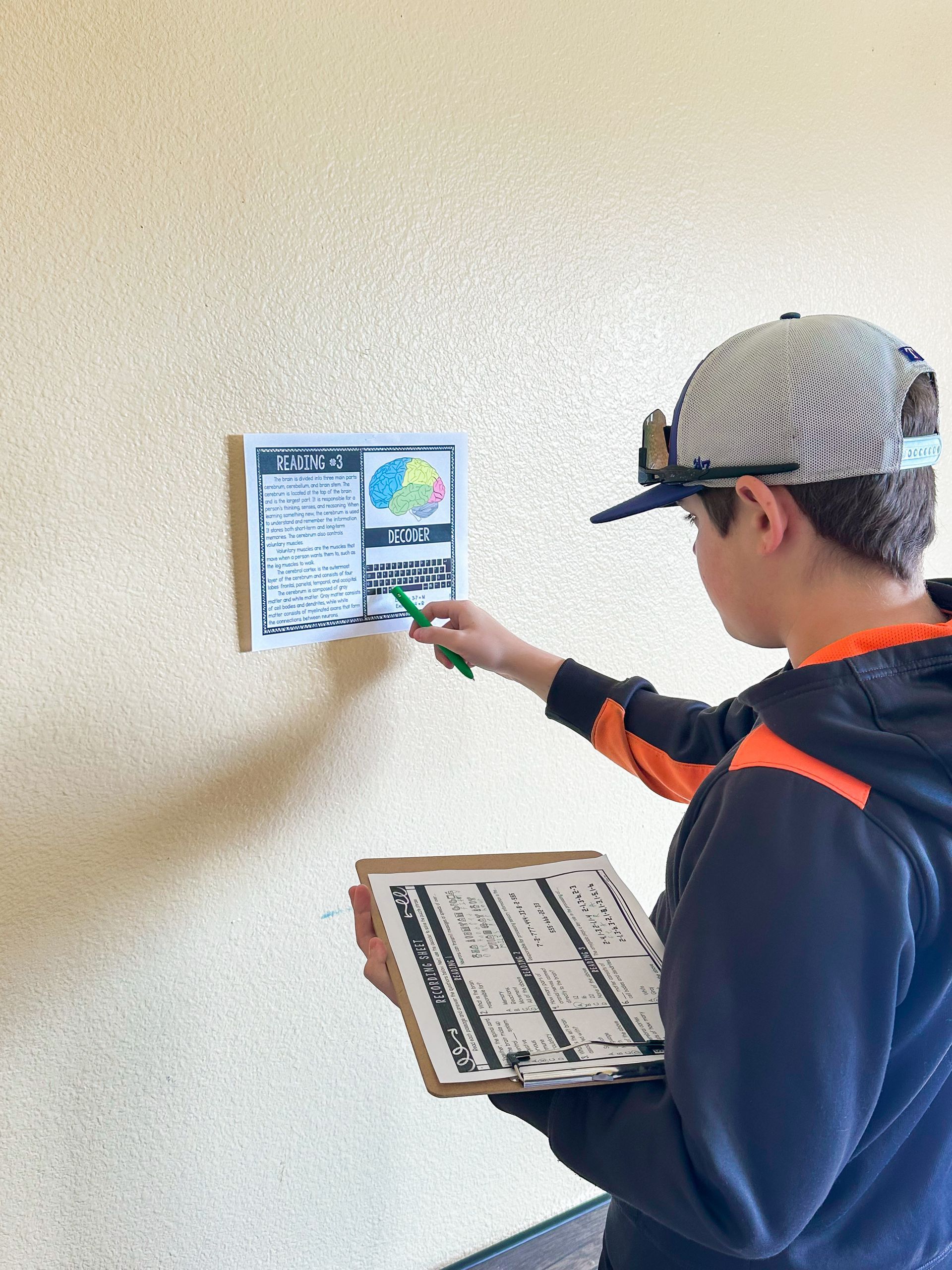A group of children sit around a table with a poster on the wall that says earth news