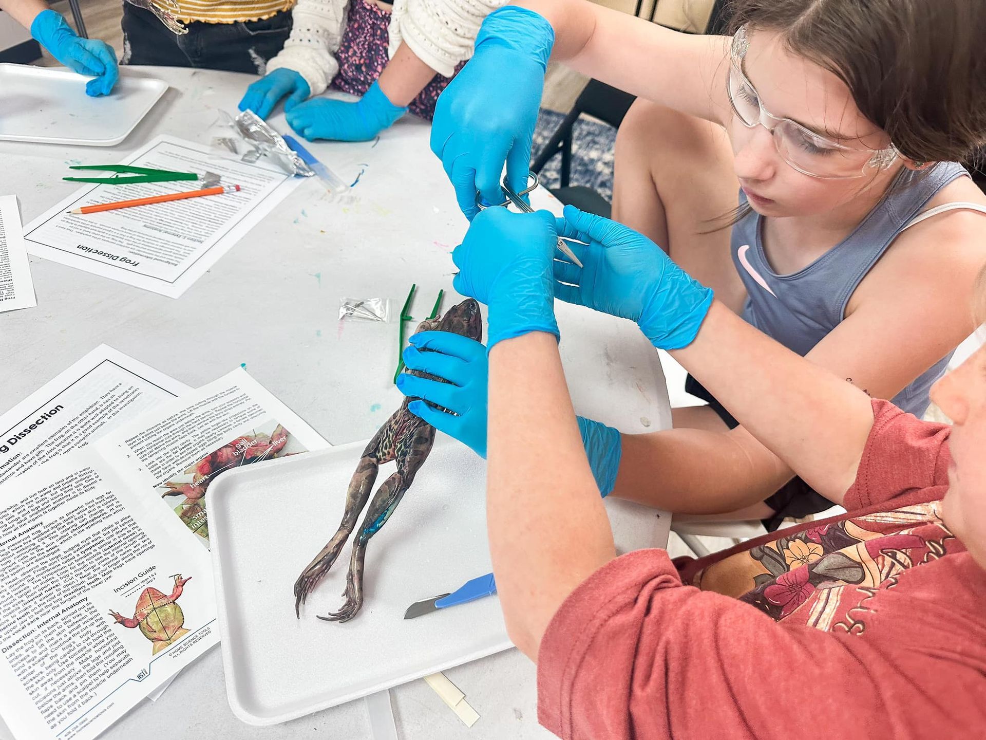 A young boy in a yellow shirt is standing in front of a white board with sticky notes on it.