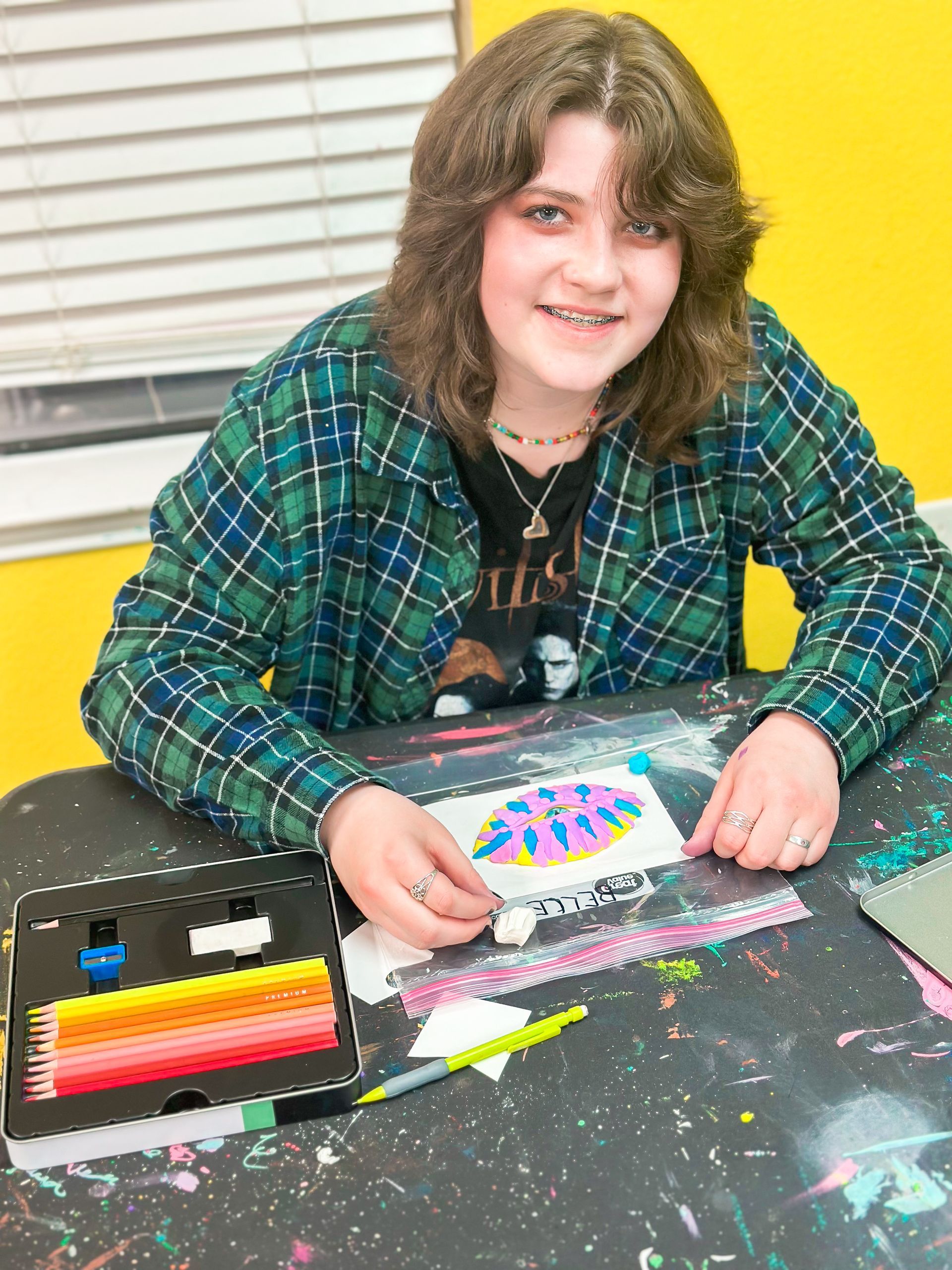 A little girl in a frankenstein costume is standing on a wooden floor.