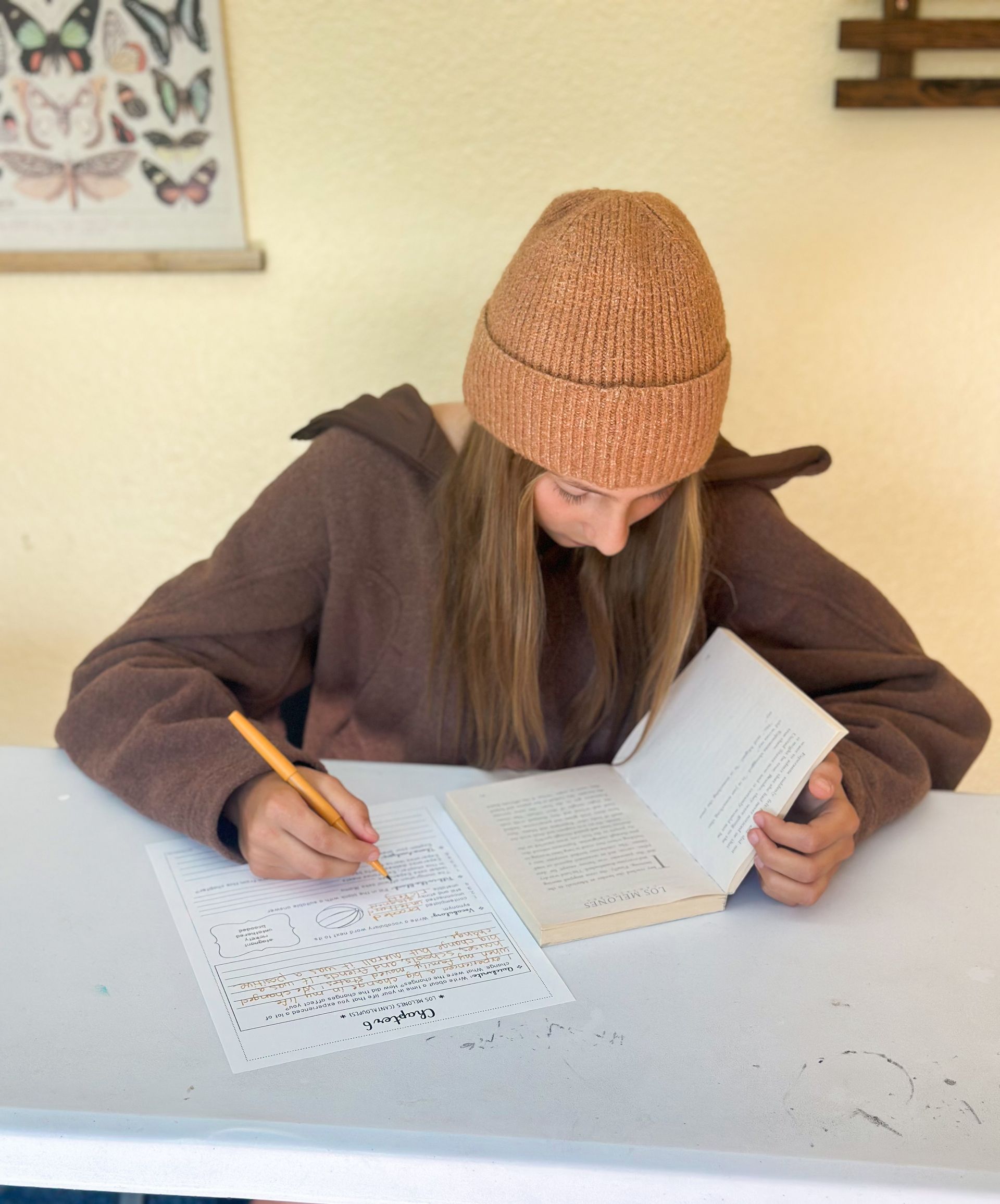 A group of children are sitting at a table with pencils.