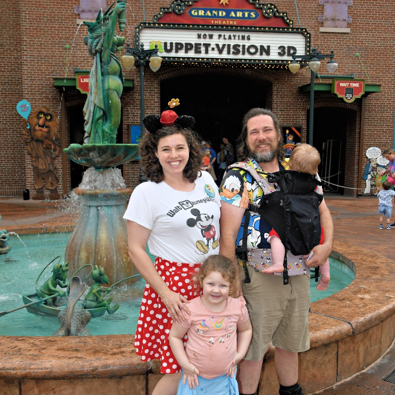A family standing in front of a fountain in front of a grand arts theater