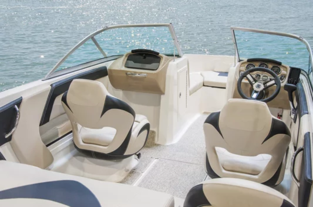 The inside of a boat with a steering wheel and seats