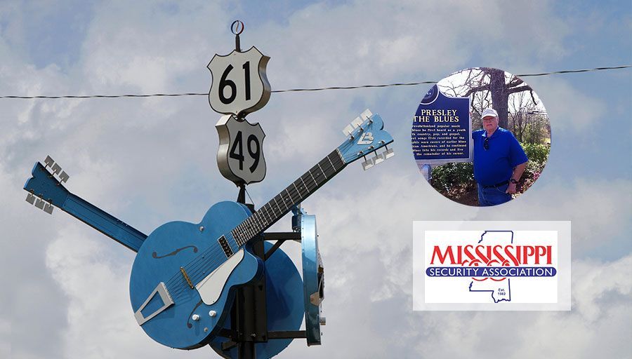 Blue guitar sculpture with highway signs.