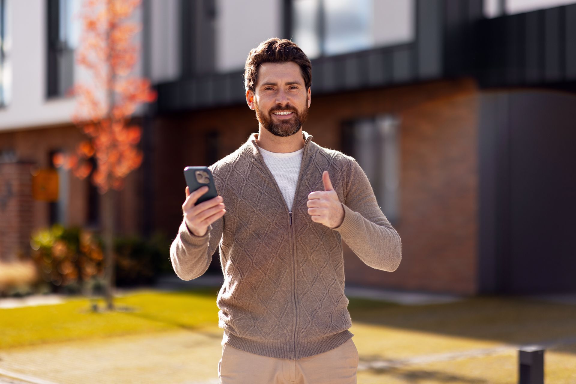 Man with beard holding phone.