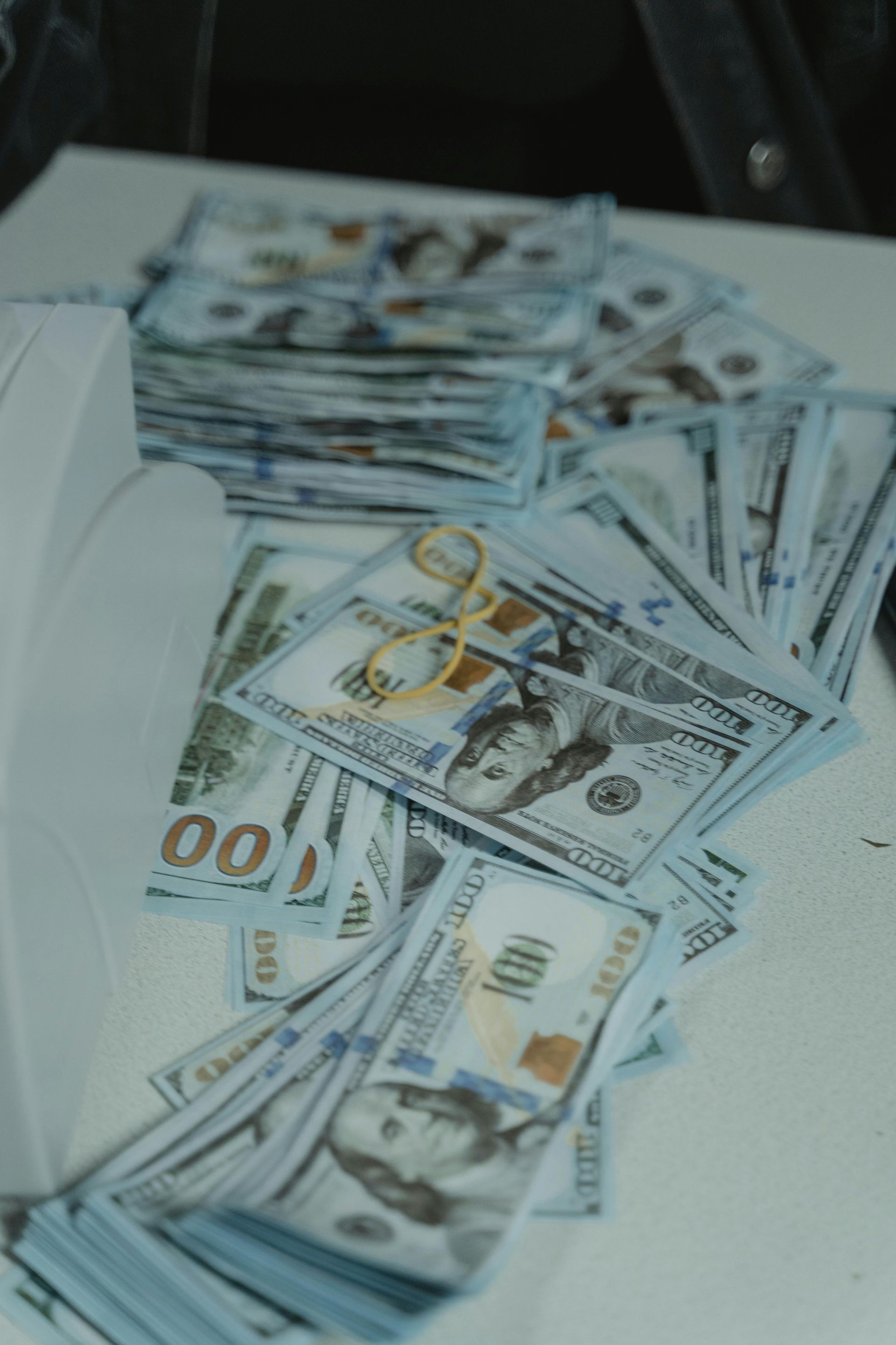 Stacks of U.S. hundred-dollar bills fanned out on a white surface