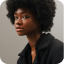 A woman with afro hair is wearing a black jacket.