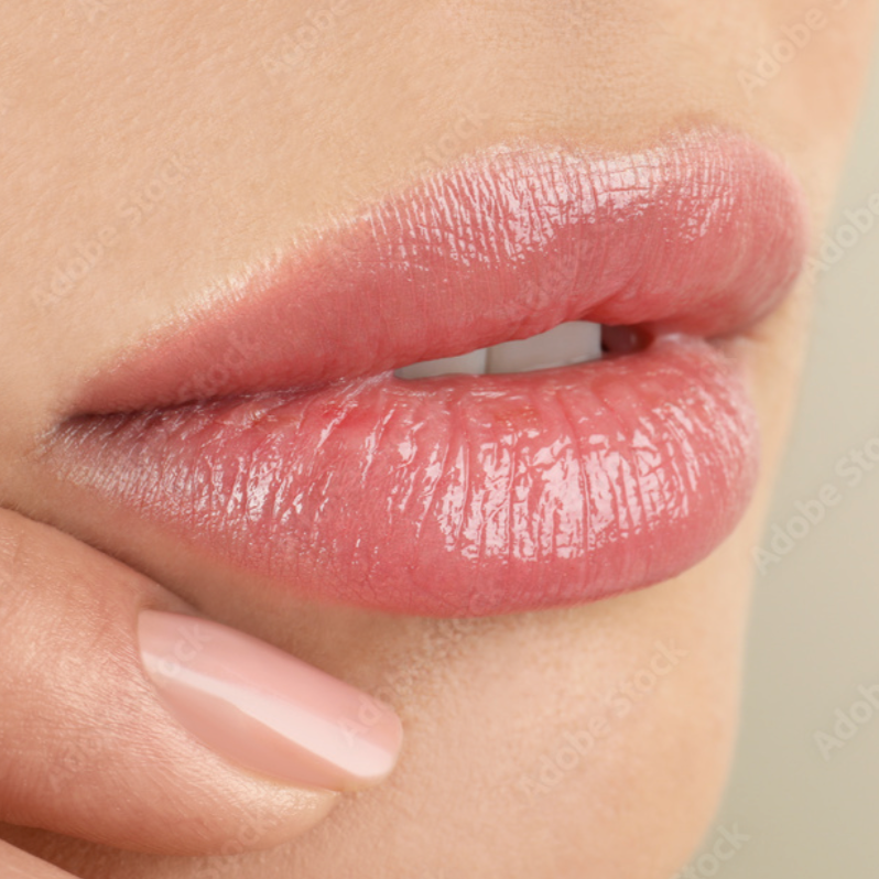 A close up of a woman 's lips with pink lipstick.