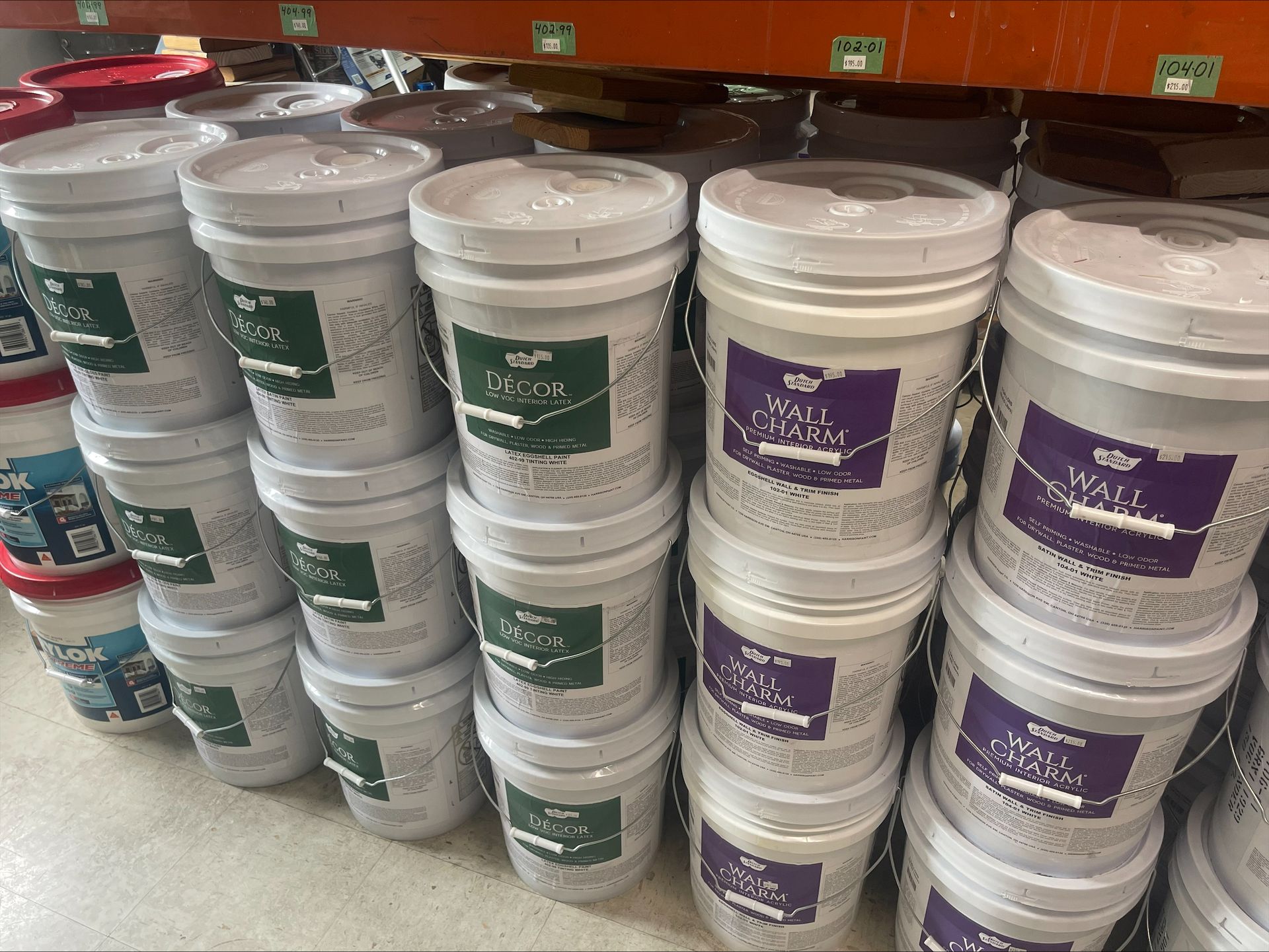 Buckets of paint are stacked on top of each other in a store.