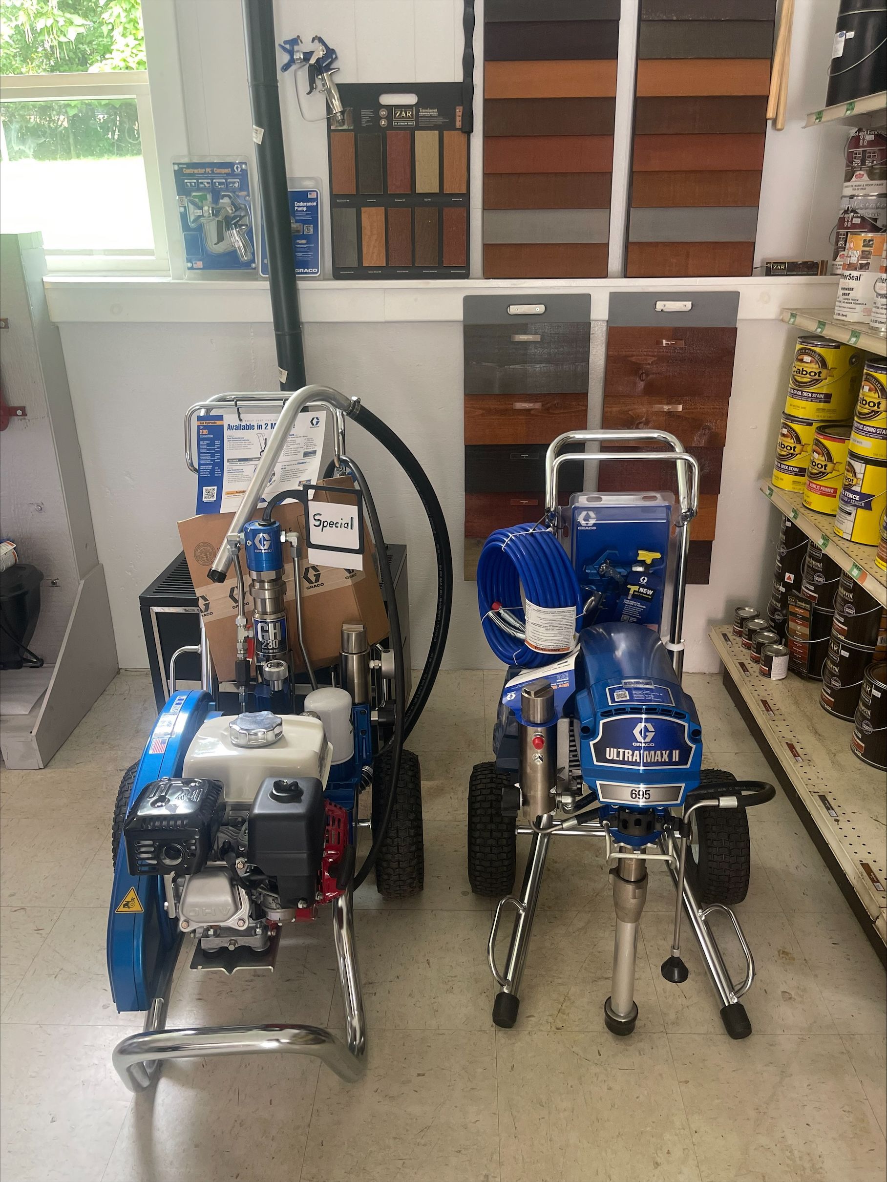 Two paint sprayers are sitting next to each other in a room.