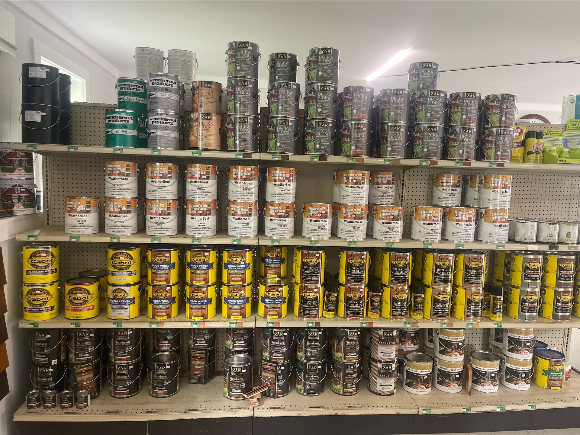 A store shelf filled with lots of cans of paint.