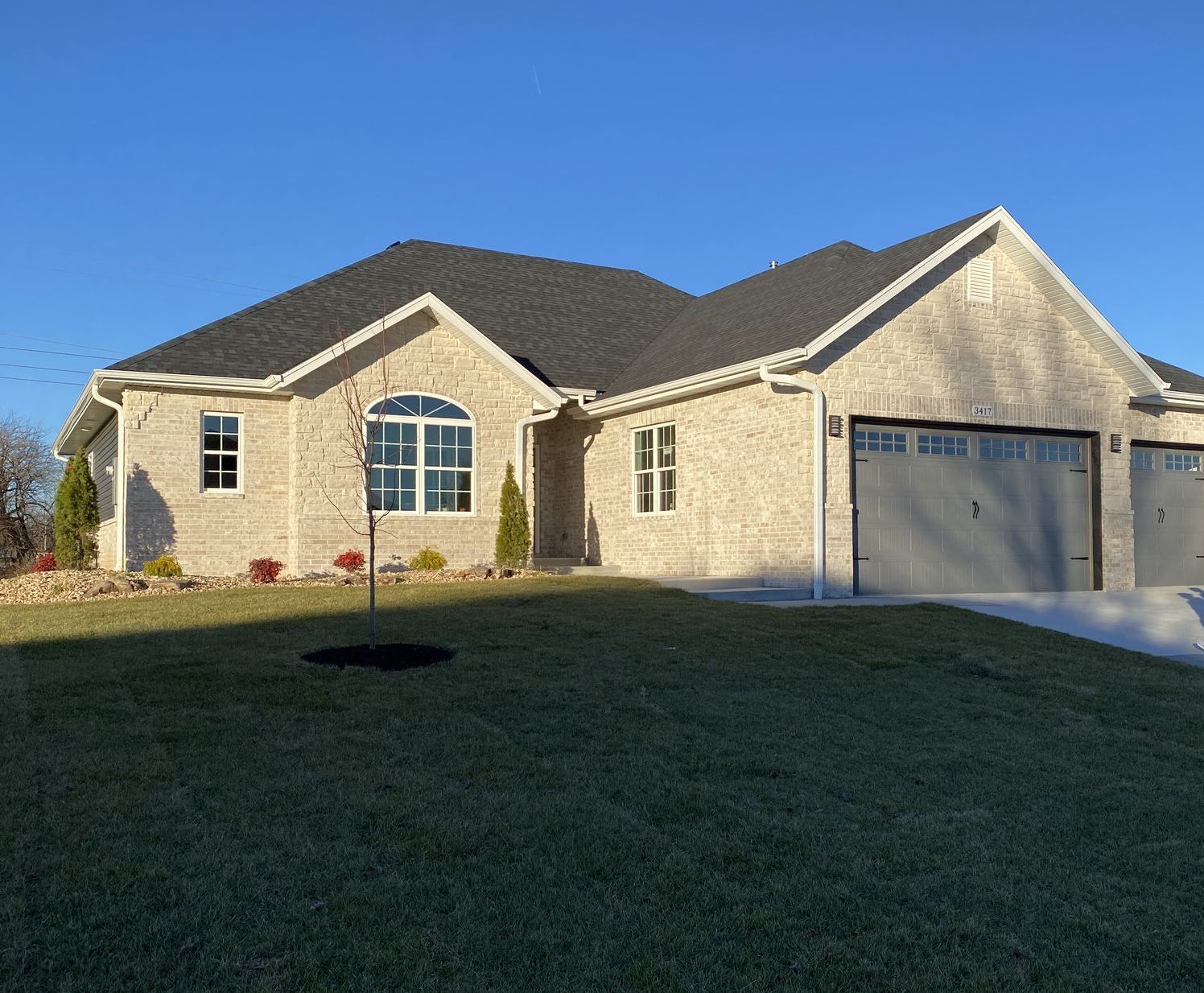 A brick house with a tree in front of it