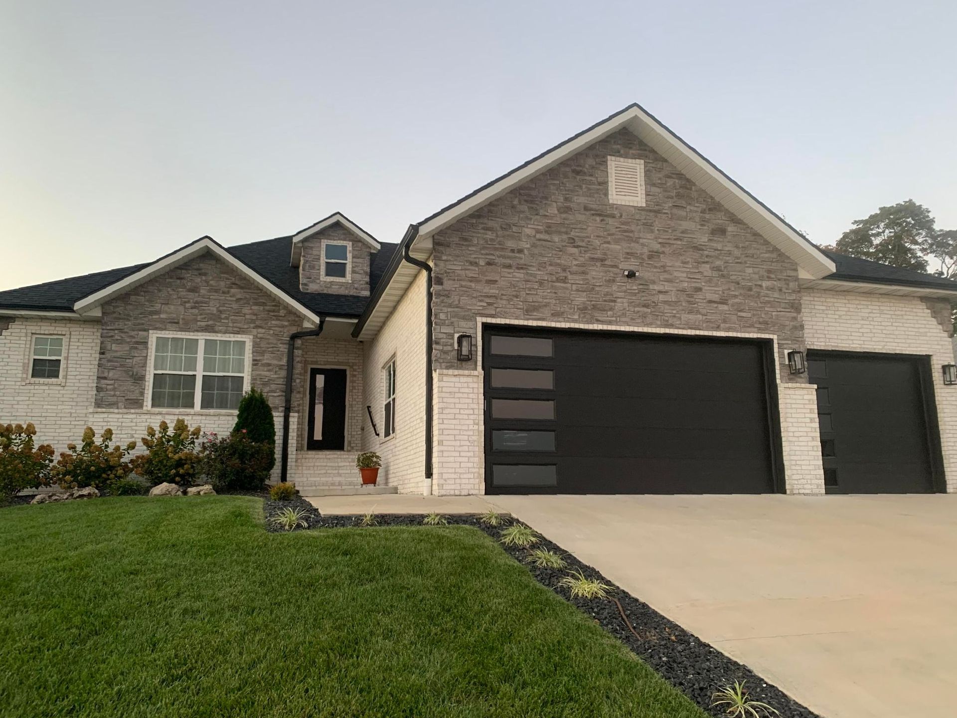 A large brick house with a black garage door