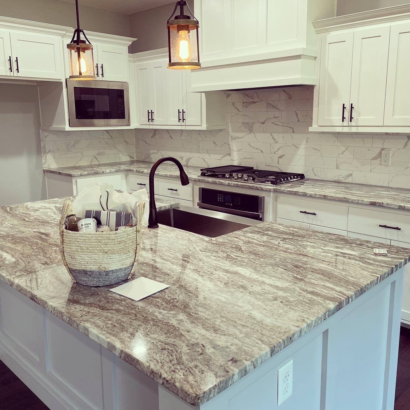 A kitchen with granite counter tops and white cabinets