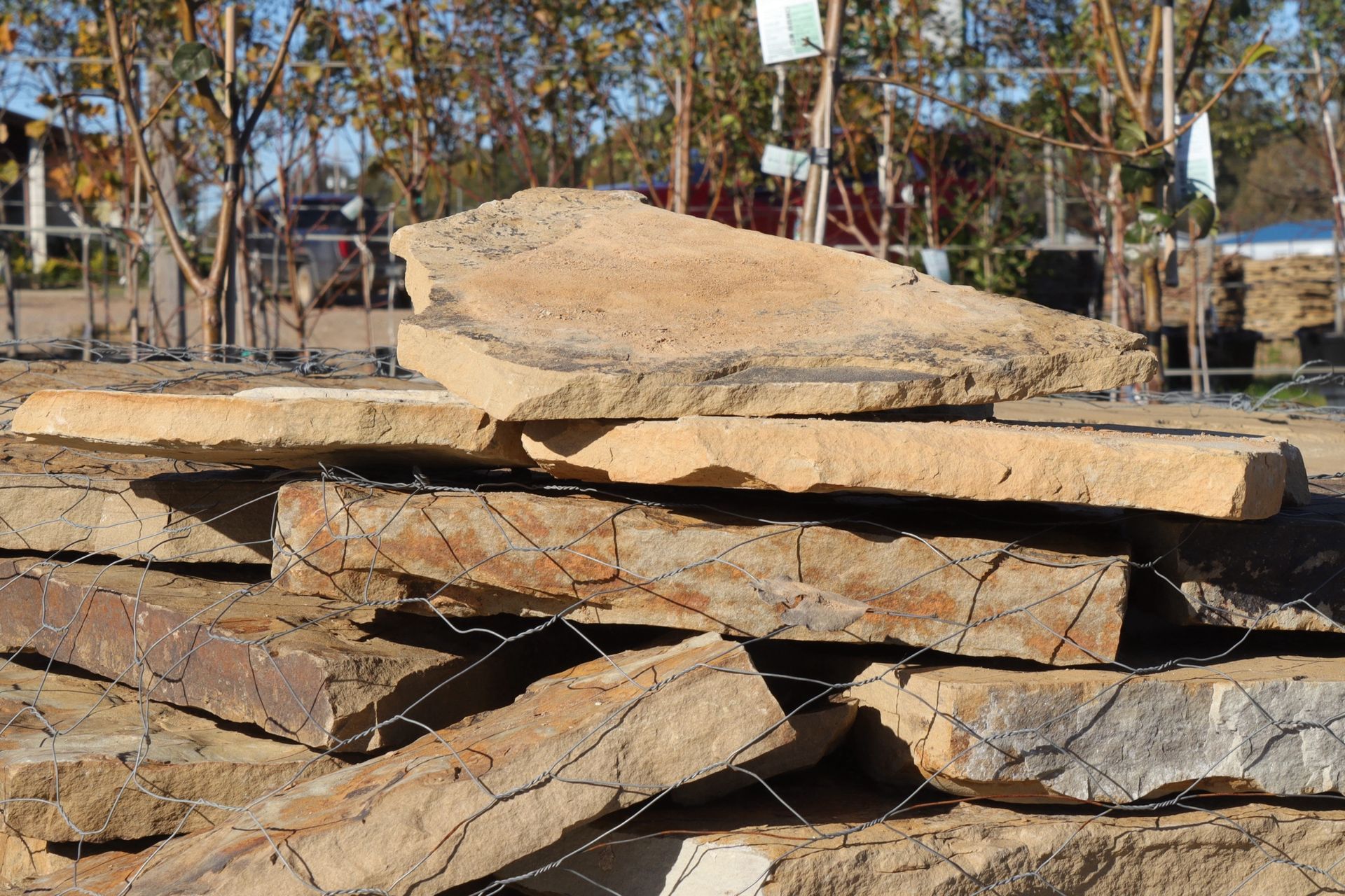 A pile of rocks sitting on top of each other behind a fence.