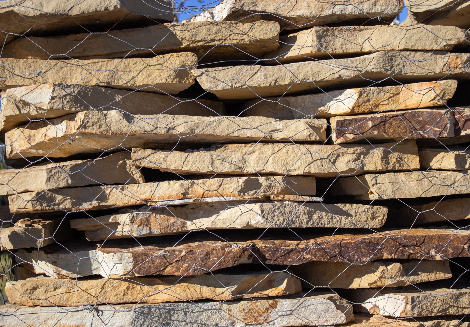 A pile of rocks stacked on top of each other behind a chain link fence.