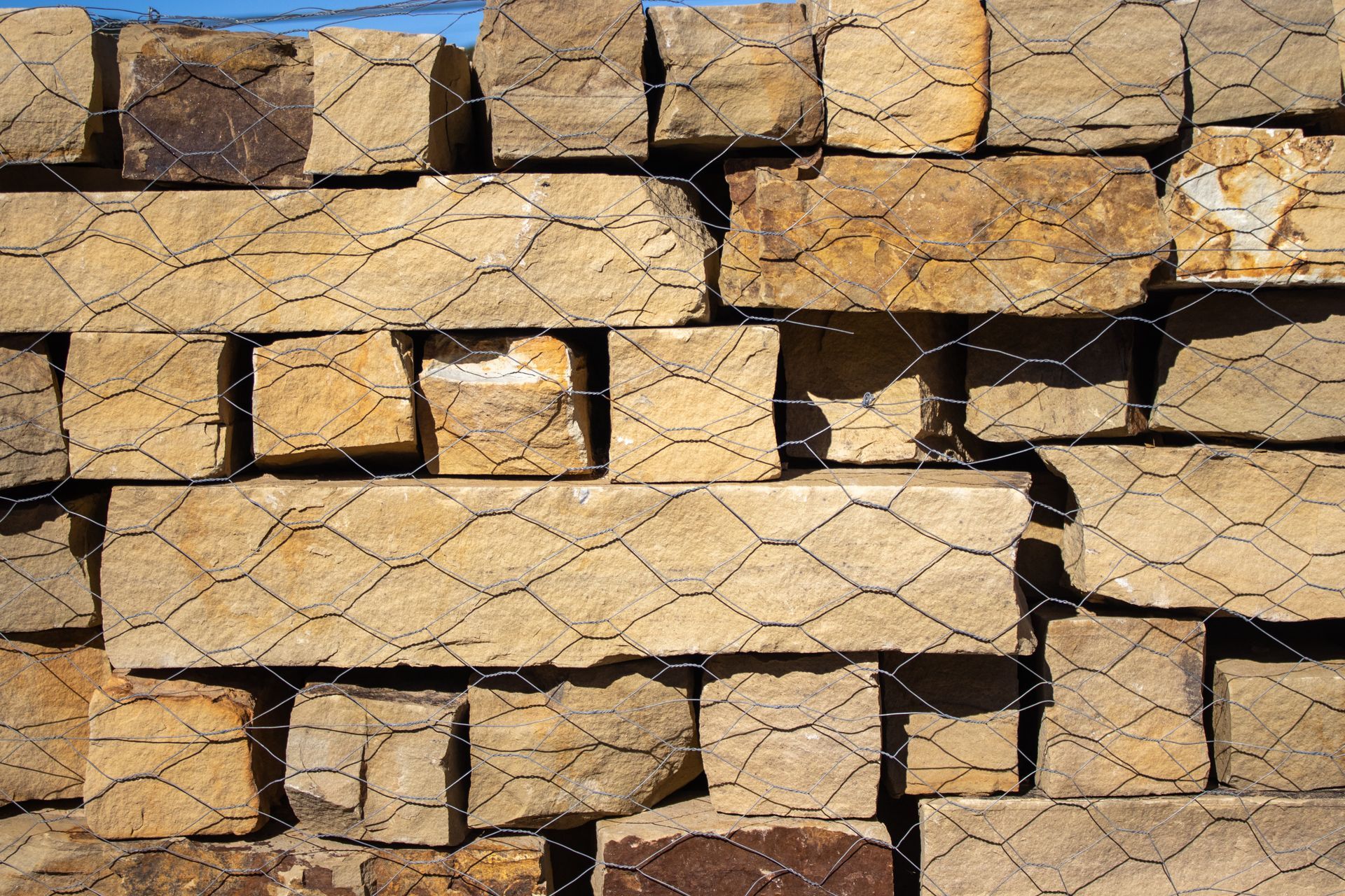 A stack of bricks behind a chain link fence